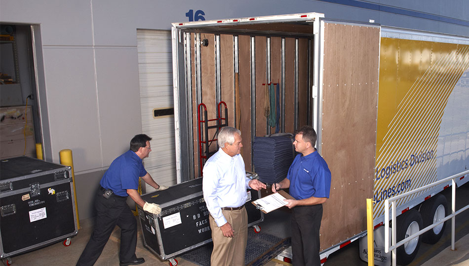 Three men unloading a united van lines truck.