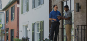 Two men stand on the front porch of a house finishing a corporate relocation.