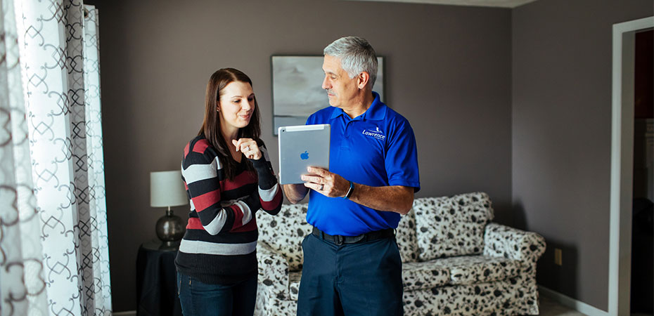 A mover talking to a woman shower her a tablet.