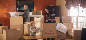 woman man and child packing lawrence moving boxes in front of a fireplace.