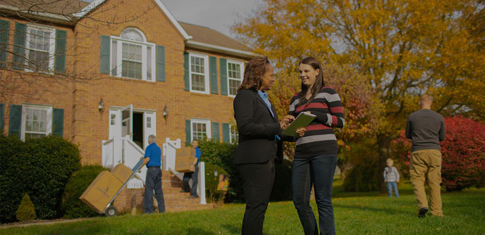 A moving company moving boxes out of a house during a residential move.