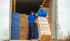 A Mover unloading five boxes off a truck with a dolly.