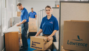 Movers in an office moving and unboxing boxes.