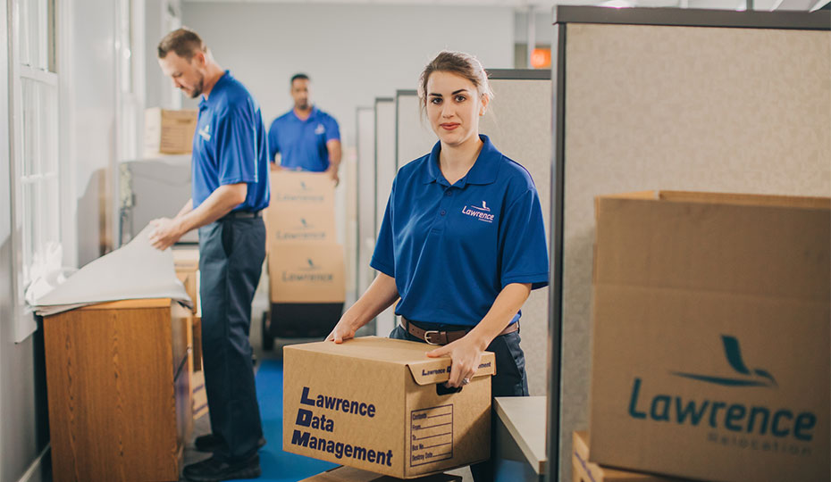 Movers in an office moving and unboxing boxes.