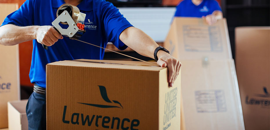 A mover is taping up a box.