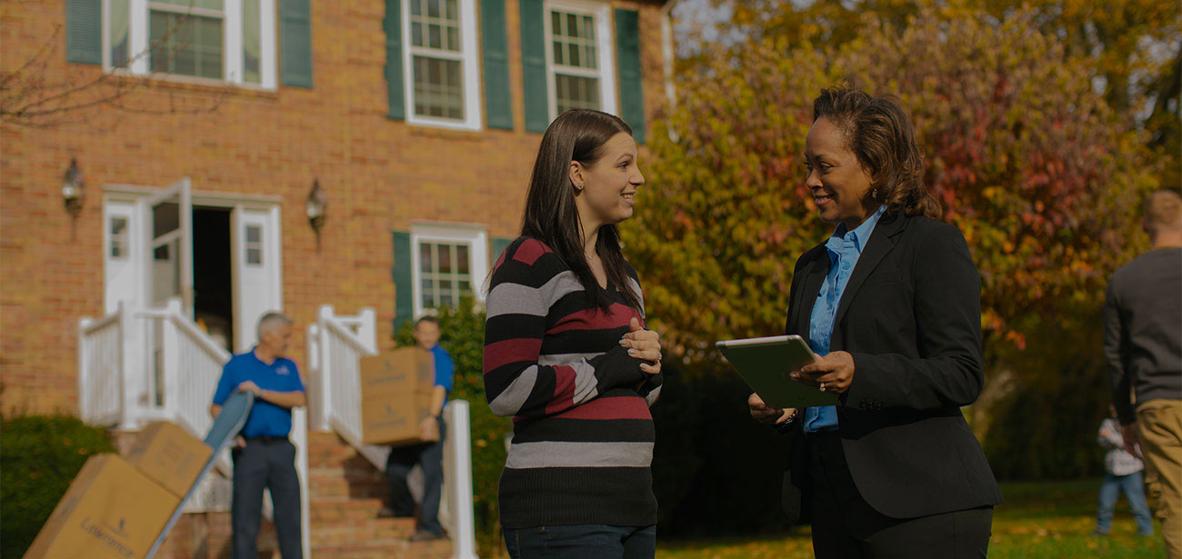 A moving expert and homeowner in the front yard.