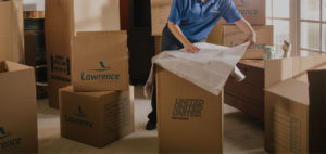 A mover wrapping items to be placed in a box.