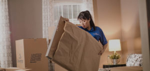 A mover carriers a brown paper wrapped item.