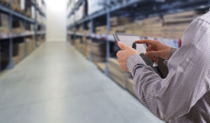 A man looks at a table in a warehouse.