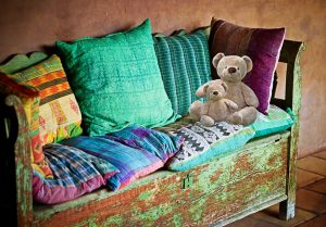 sofa with a baby teddy bear and a large teddy bear leaning against pillows