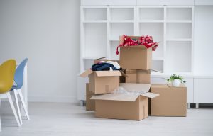 Moving boxes packed up in a white room in front of empty bookcases