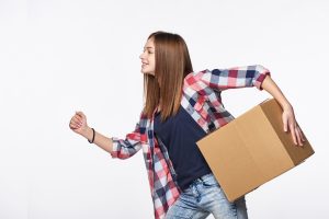 Woman in a plaid shirt running with a moving box