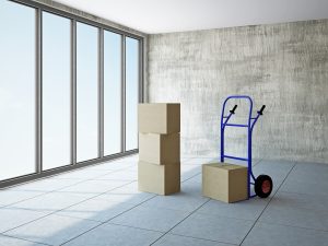 Empty office room with boxes and pushcart near the window