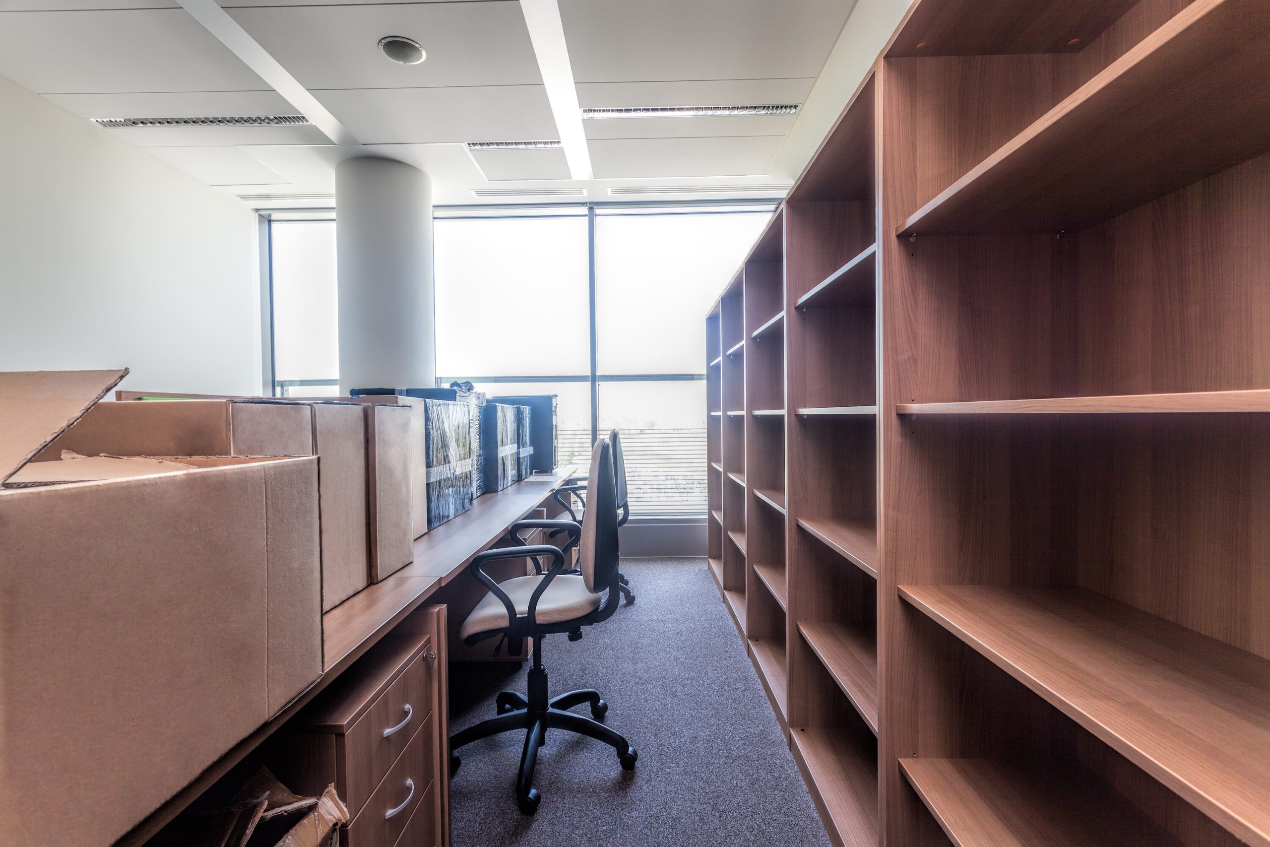 Office relocation with packup up moving cartons on office desks.