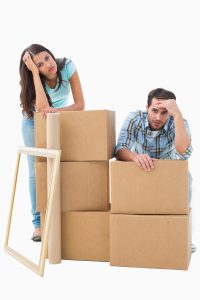 Stressed out couple with stacks of moving boxes.
