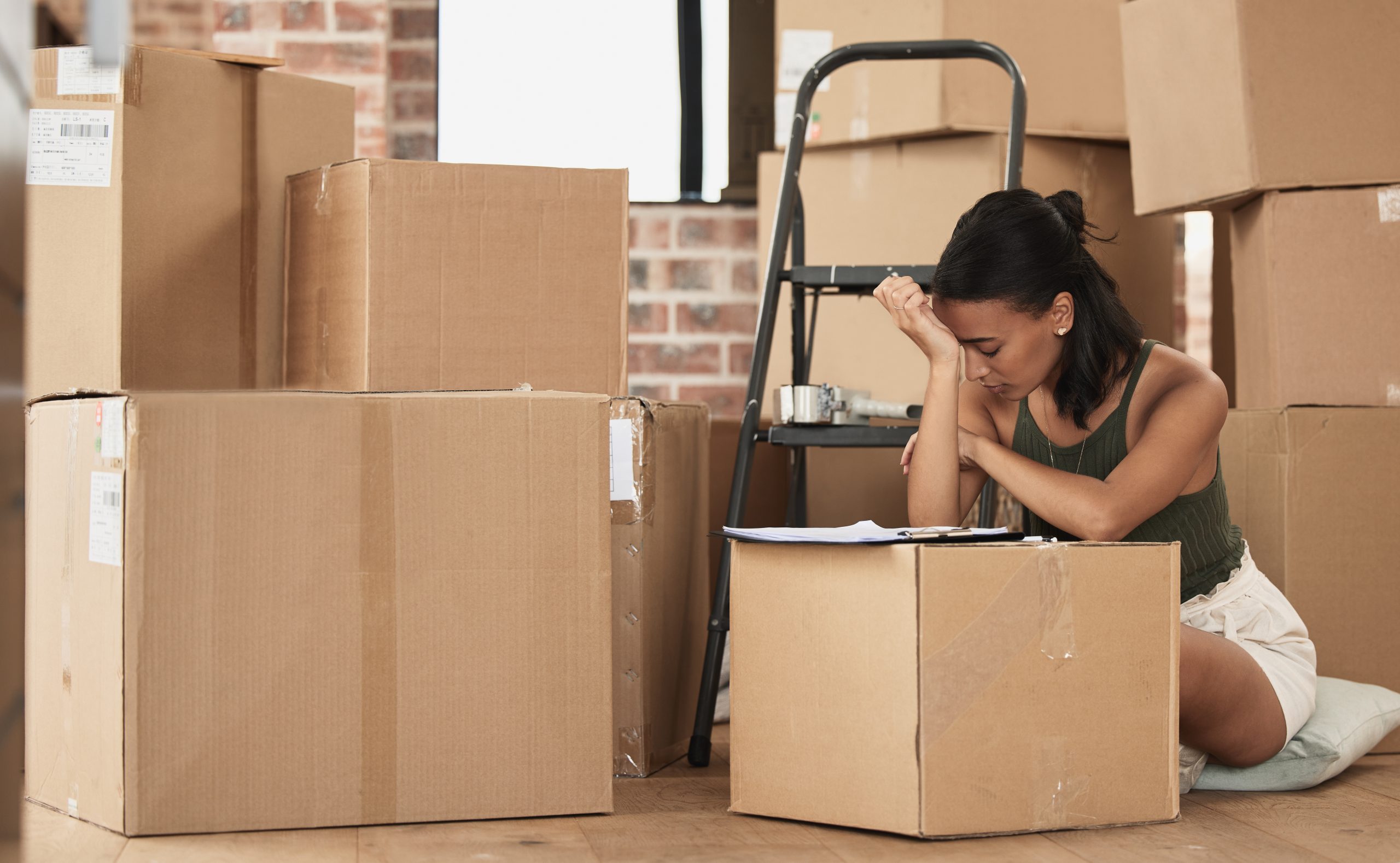 Shot of a young woman having a stressful day during packing at home